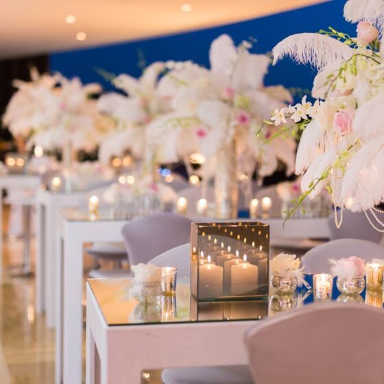 Elegant event floral décor with soft pink flowers, candles, and table arrangements created by Victoria Florist in Barbados.