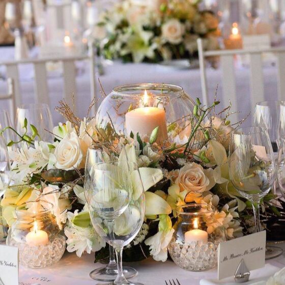 Wedding reception centrepiece with white flowers and candle décor created by Victoria Florist for a Barbados wedding.